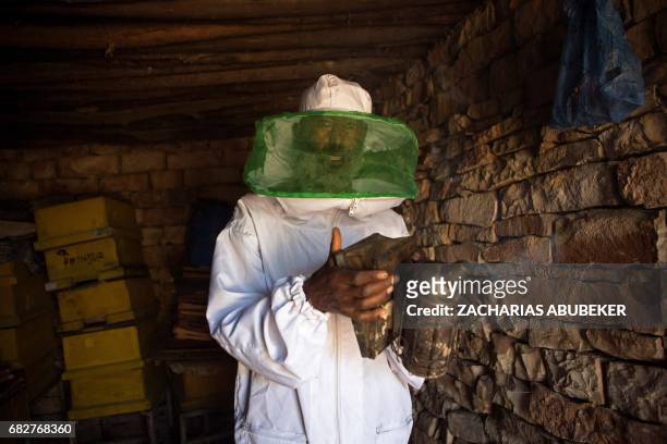 Honey farmer Alem Abreha is pictured prepares a bee smoker on his honey farm outside Wukro in the Tigray region of northern Ethiopia on March 29,...