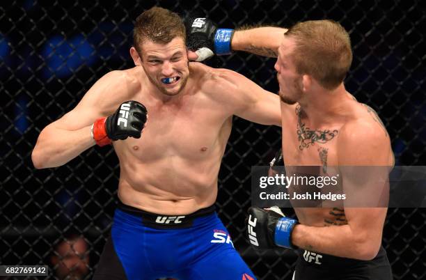 Jason Knight punches Chas Skelly in their featherweight fight during the UFC 211 event at the American Airlines Center on May 13, 2017 in Dallas,...