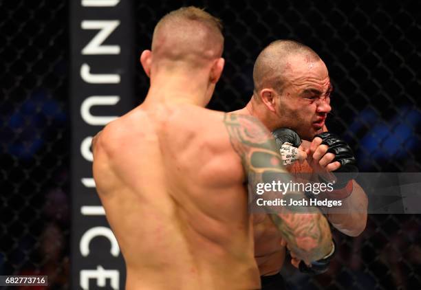 Dustin Poirier punches Eddie Alvarez in their lightweight fight during the UFC 211 event at the American Airlines Center on May 13, 2017 in Dallas,...