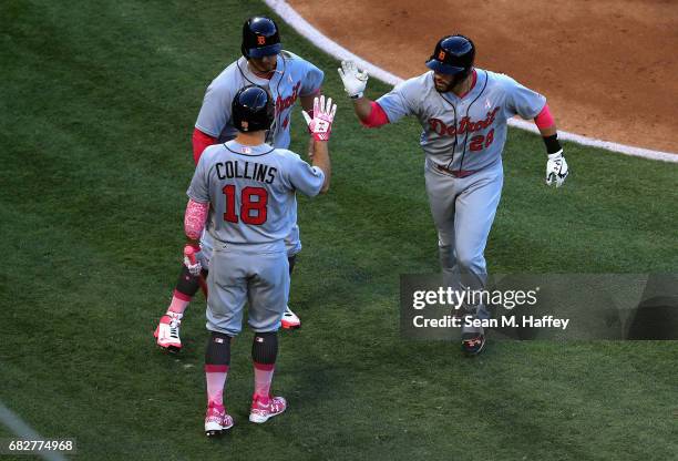 Martinez is congratulated by Tyler Collins and Victor Martinez of the Detroit Tigers after hitting a two-run homerun during the second inning of a...