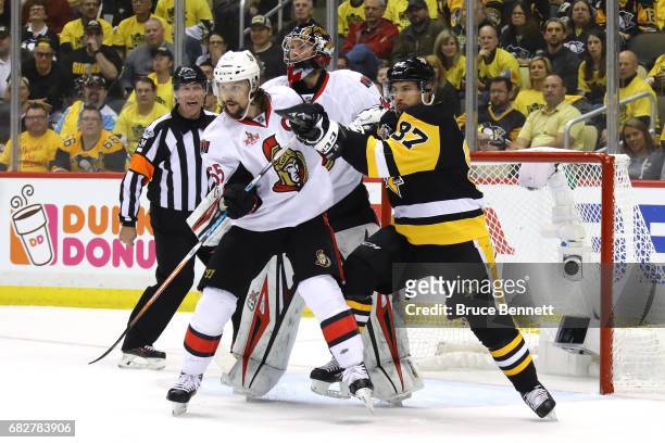 Sidney Crosby of the Pittsburgh Penguins fights for position against Erik Karlsson of the Ottawa Senators during the third period in Game One of the...