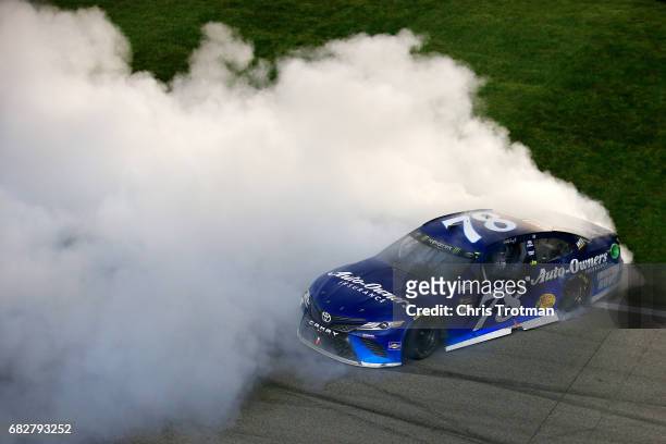 Martin Truex Jr., driver of the Auto-Owners Insurance Toyota, celebrates with a burnout after winning the Monster Energy NASCAR Cup Series Go Bowling...