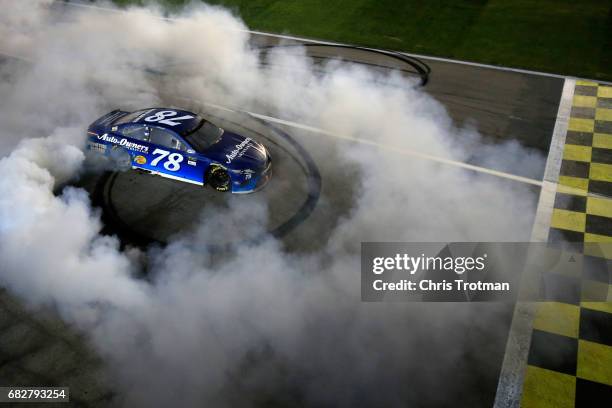 Martin Truex Jr., driver of the Auto-Owners Insurance Toyota, celebrates with a burnout after winning the Monster Energy NASCAR Cup Series Go Bowling...