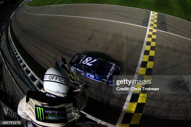 Martin Truex Jr., driver of the Auto-Owners Insurance Toyota, takes the checkered flag to win the Monster Energy NASCAR Cup Series Go Bowling 400 at...