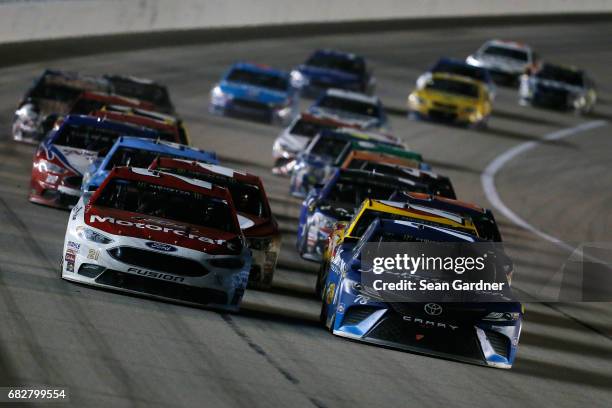 Martin Truex Jr., driver of the Auto-Owners Insurance Toyota, leads Ryan Blaney, driver of the Motorcraft/Quick Lane Tire & Auto Center Ford, during...