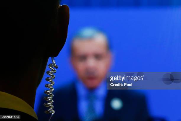 Security guard stands near a screen showing Turkish President Recep Tayyip Erdogan during his speach at the opening ceremony of the Belt and Road...