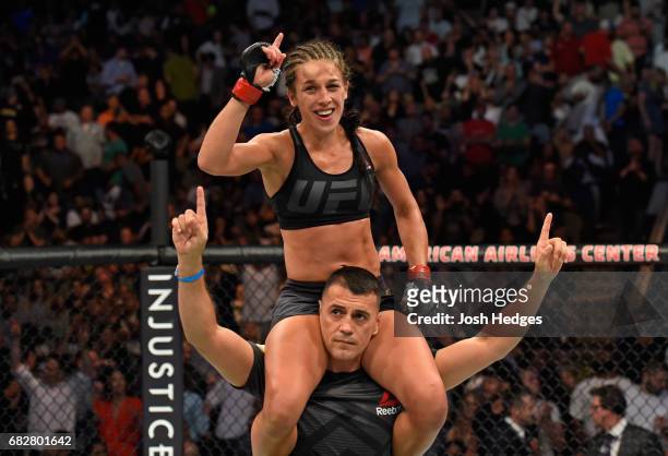 Joanna Jedrzejczyk raises her hands after facing Jessica Andrade in their UFC women's strawweight championship fight during the UFC 211 event at the...