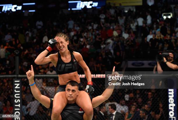 Joanna Jedrzejczyk raises her hands after facing Jessica Andrade in their UFC women's strawweight championship fight during the UFC 211 event at the...