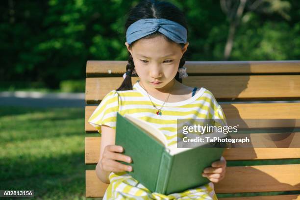 reading on a bench in the park - time life authors stock pictures, royalty-free photos & images