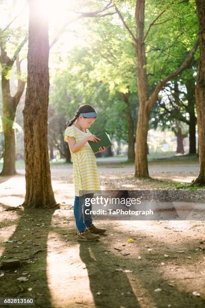 reading a book standing in the park - time life authors stock pictures, royalty-free photos & images