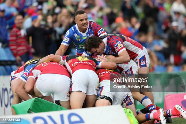 Knights players celebrate a try during the round 10 NRL match between the Newcastle Knights and the Canberra Raiders at McDonald Jones Stadium on May...