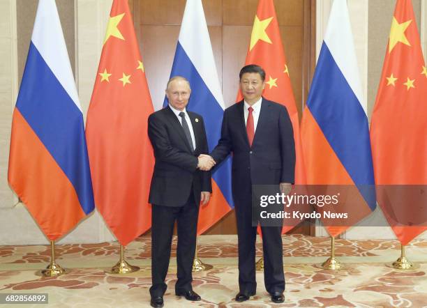 Russian President Vladimir Putin and Chinese President Xi Jinping shake hands ahead of their talks in Beijing on May 14, 2017. They met on the...