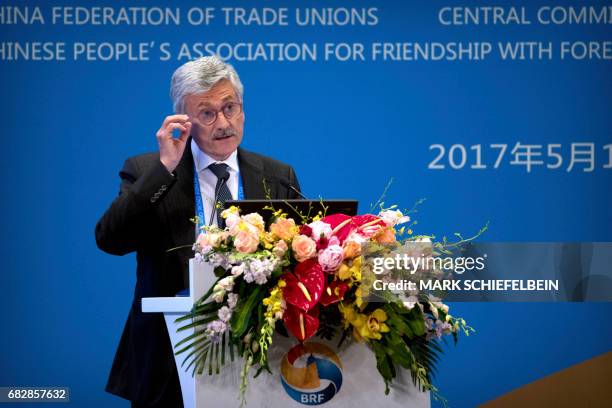 Former Italian Prime Minister Massimo D'Alema adjusts his glasses as he speaks during a session on people-to-people connectivity of the Belt and Road...