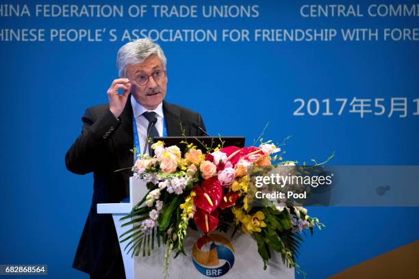 Former Italian Prime Minister Massimo D'Alema adjusts his glasses as he speaks during a session on people-to-people connectivity of the Belt and Road...