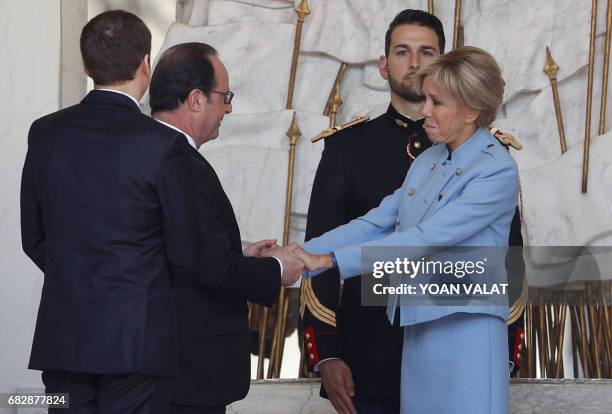 French outgoing President Francois Hollande greets Emmanuel Macron's wife Brigitte Trogneux at the Elysee presidential Palace at the end of the...