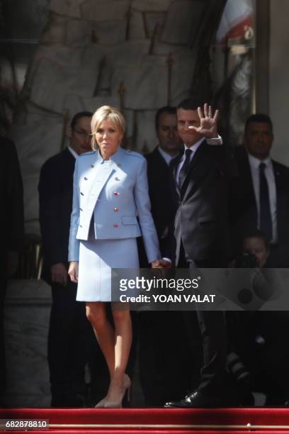 French newly elected President Emmanuel Macron waves next to his wife with his wife Brigitte Trogneux at the Elysee presidential Palace before his...