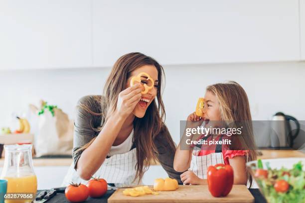 mom and daughter playing with pepper slices - mom flirting stock pictures, royalty-free photos & images