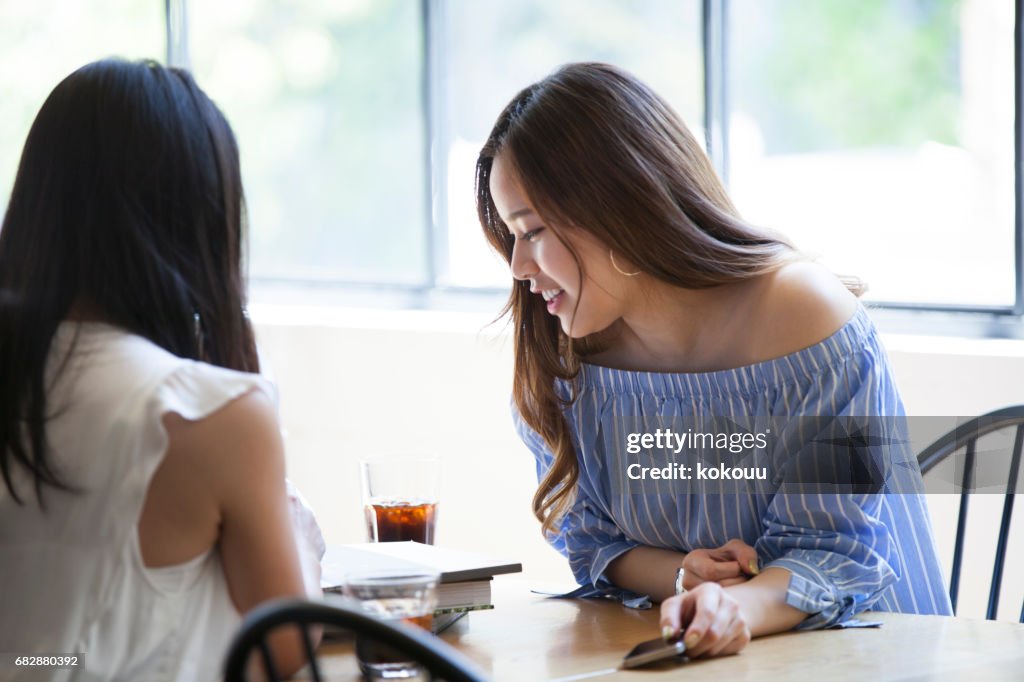 Two college girls spend a quiet morning at a cafe.