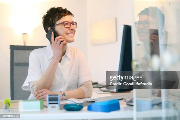 female doctor working in office - doctor using phone stock pictures, royalty-free photos & images