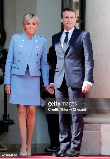 Newly-elected President Emmanuel Macron and his wife Brigitte Trogneux pose on the steps of the Elysee Palace after the handover ceremony with...