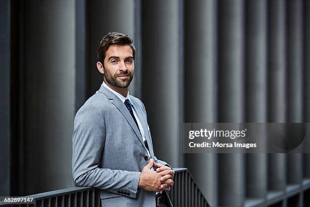 confident businessman with hands clasped outdoors - luta fysisk ställning bildbanksfoton och bilder