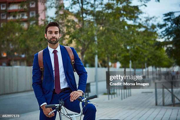 male executive riding bicycle on sidewalk - short trees bildbanksfoton och bilder