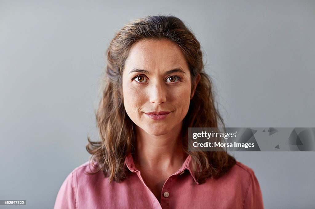 Confident businesswoman over gray background