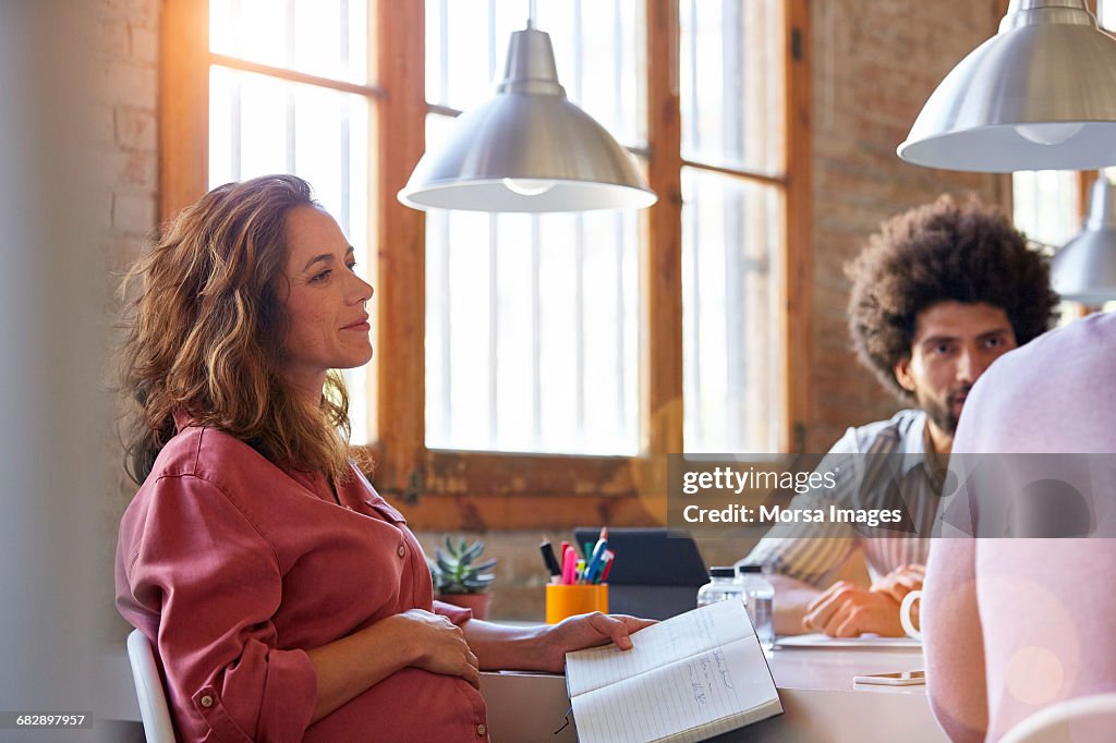 Pregnant businesswoman with colleagues in office