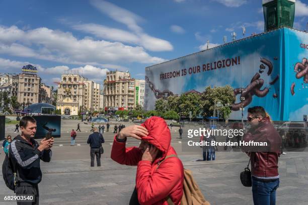 People visit Independence Square, where a large banner reading Freedom is Our Religion was hung on the former Trade Unions building, which burned...