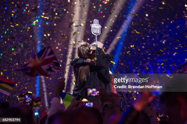 Salvador Sobral, the contestant from Portugal, holds the trophy and hugs his sister Luisa Sobral, who wrote his winning song, after being announced...
