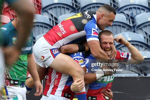 Nathan Ross of the Knights celebrates his try with team mates during the round 10 NRL match between the Newcastle Knights and the Canberra Raiders at...