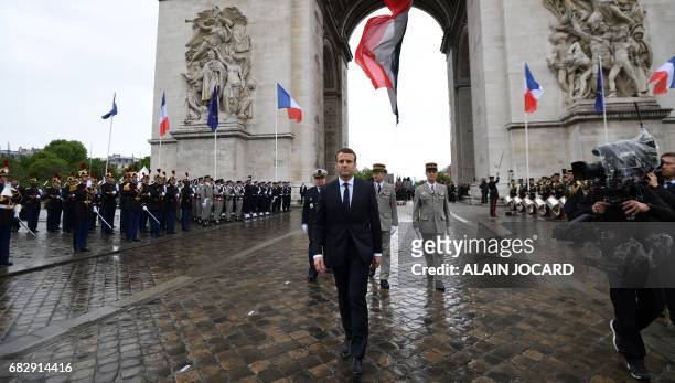 French President Emmanuel Macron walks after laying a wreath on the unknown Soldier's tomb at the Arc of Triomphe monument after his formal...