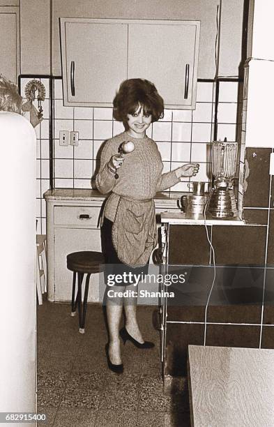 vintage photo of a young woman in the kitchen - stereotypical homemaker stock pictures, royalty-free photos & images