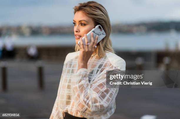 Sarah Ellen on the phone wearing a sheer top outside Dion Lee during Mercedes-Benz Fashion Week Resort 18 Collections at Sydney Opera House on May...