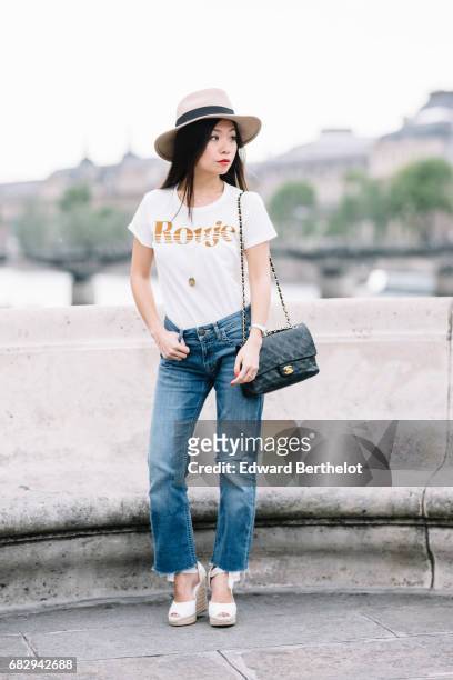 May Berthelot, fashion blogger and Head of Legal at Videdressing.com, wears a The Kooples hat, Maje jeans, a Rouje by Jeanne Damas t-shirt, a...