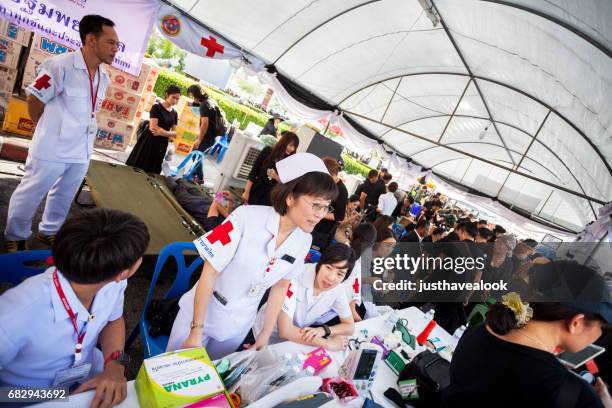 rot-kreuz-zelt und thailändische krankenschwestern in der nähe von grand palace - rotes kreuz organisierte gruppe stock-fotos und bilder