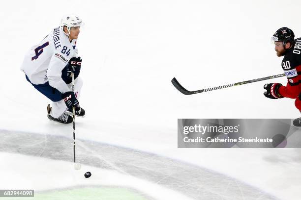 Kevin Hecquefeuille of France is looking to pass the puck against Ryan O'Reilly of Canada during the 2017 IIHF Ice Hockey World Championship game...