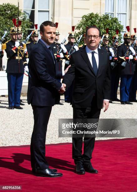 New French President elected Emmanuel Macron shakes the hand of French Former President Francois Hollande as he escorts him to his car after...