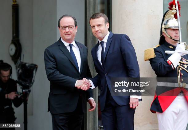 Outgoing French President Francois Hollande shakes hands with newly elected French president Emmanuel Macron prior to a handover ceremony at the...