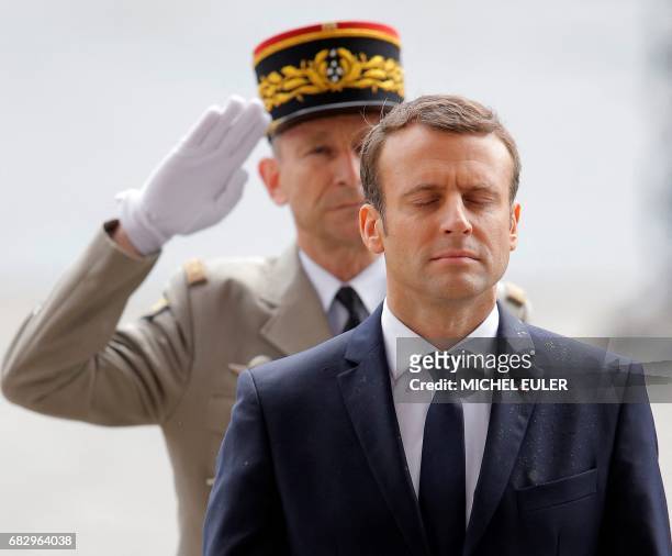 New French President Emmanuel Macron observes a minute of silence during a wreath laying ceremony at the Arc de Triomphe in Paris, after his formal...