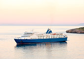 Sunset and the blue white ferry boat in greek islands