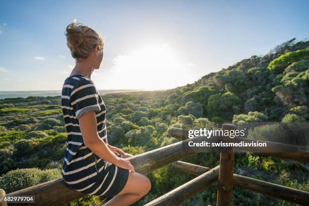 girl sitting on patio looking at beautiful sunset - sun deck stock pictures, royalty-free photos & images