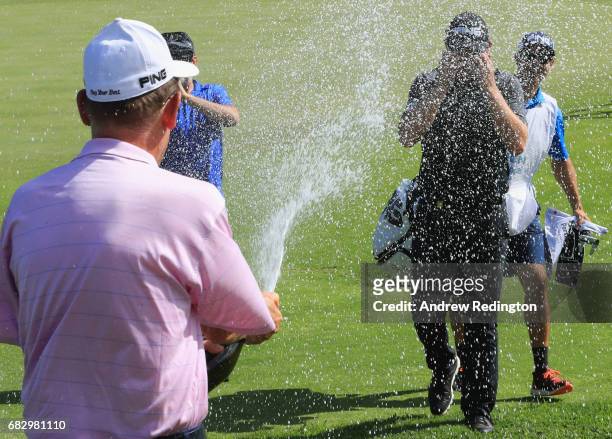 Matt Wallace of England is sprayed with champagne as he celebrates victory on the 18th green during the final round on day four of the Open de...