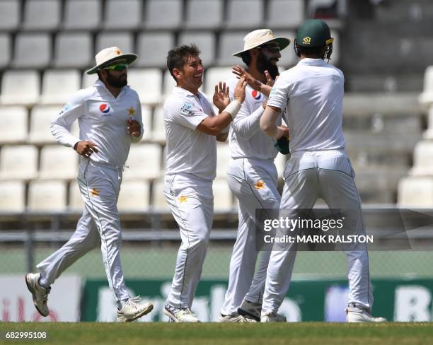 Bowler Yasir Shah of Pakistan celebrates with teammates after taking the wicket of West Indies batsman Kraigg Brathwaite who was caught by Hasan Ali...