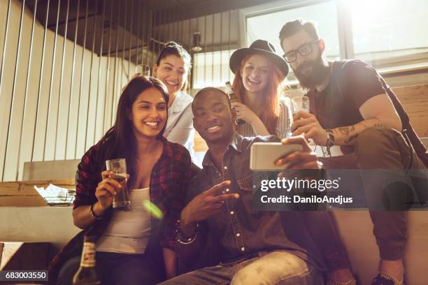 groep vrienden die een selfie maken in een bar - sun flare on glass stockfoto's en -beelden