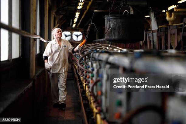 Tim Jordan removes a pot of cooked beans from the oven to be prepared for canning. There are 60 ovens in the century-old facility. The beans are...