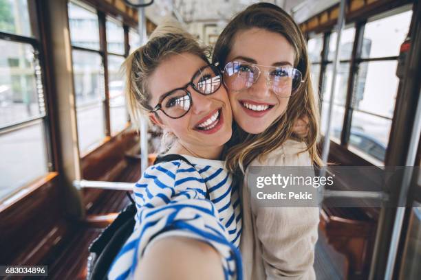 schwestern nehmen selfie in oldtimer-straßenbahn - two people travelling stock-fotos und bilder