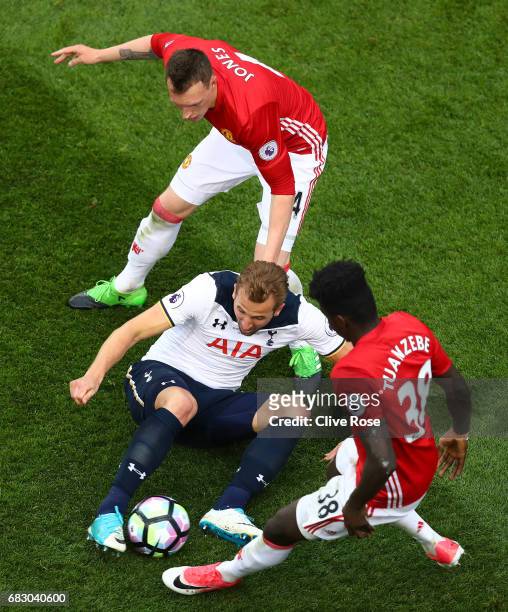Harry Kane of Tottenham Hotspur, Phil Jones of Manchester United and Axel Tuanzebe of Manchester United all battle for possesion during the Premier...