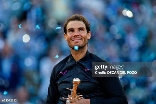 Spanish tennis player Rafael Nadal poses with his trophy as he celebrates his victory over Austrian tennis player Dominic Thiem at the end of their...