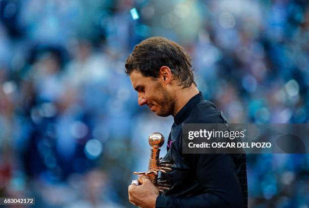 Spanish tennis player Rafael Nadal poses with his trophy as he celebrates his victory over Austrian tennis player Dominic Thiem at the end of their...